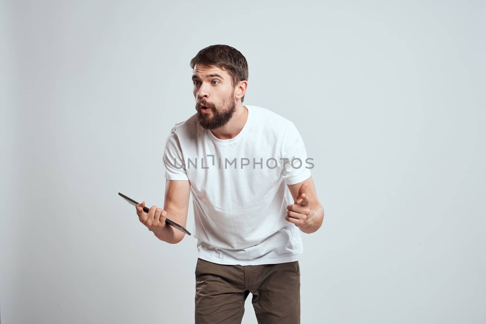 emotional man with tablet in hand touch screen new technologies light background cropped view Copy Space. High quality photo