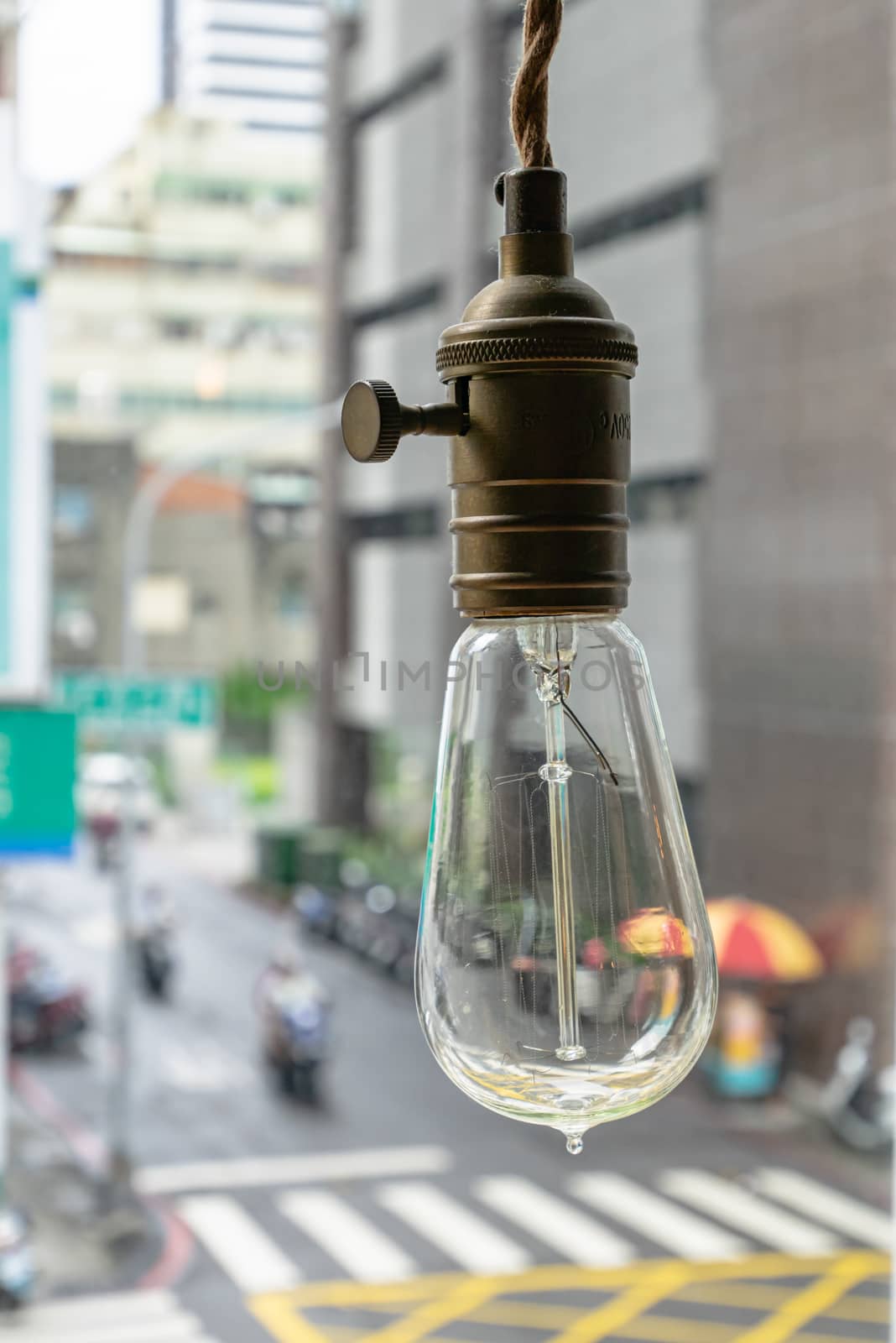 The close up of vintage light bulb aesthetic hanging with downtown background.