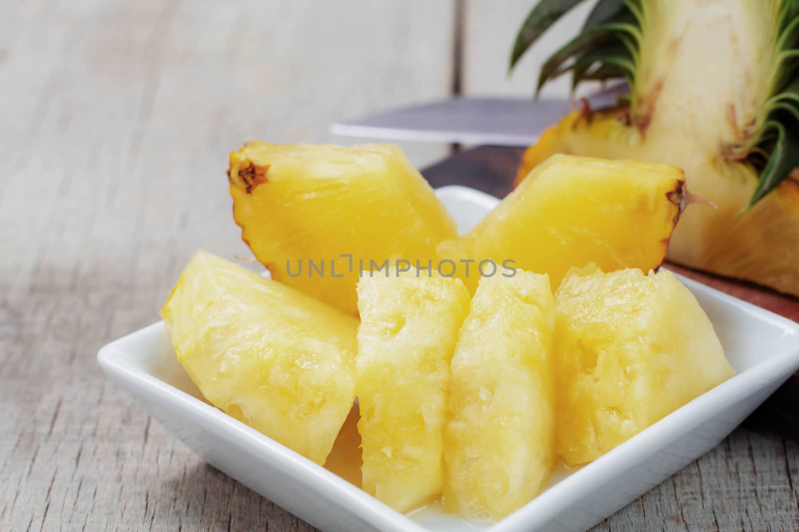 Pineapple sliced ​​on a plate of wooden table.
