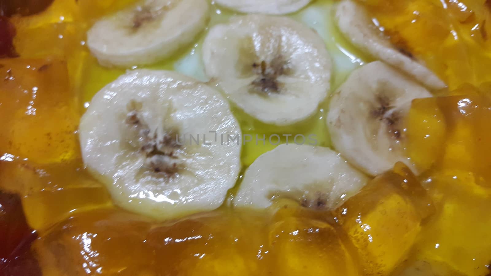 Creamy tasty sweet custard with banana pieces layered on surface. A close up top view of home made custard, a dairy products for dessert after meal.