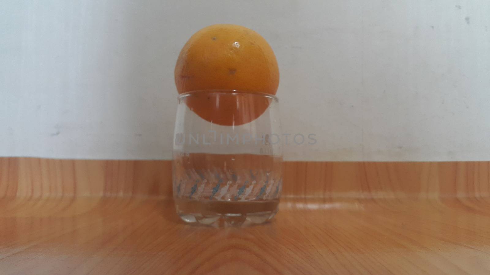 Close up view of oranges on white glass over wooden floor background. Fruit with wood background. Healthy benefits of Orange. 