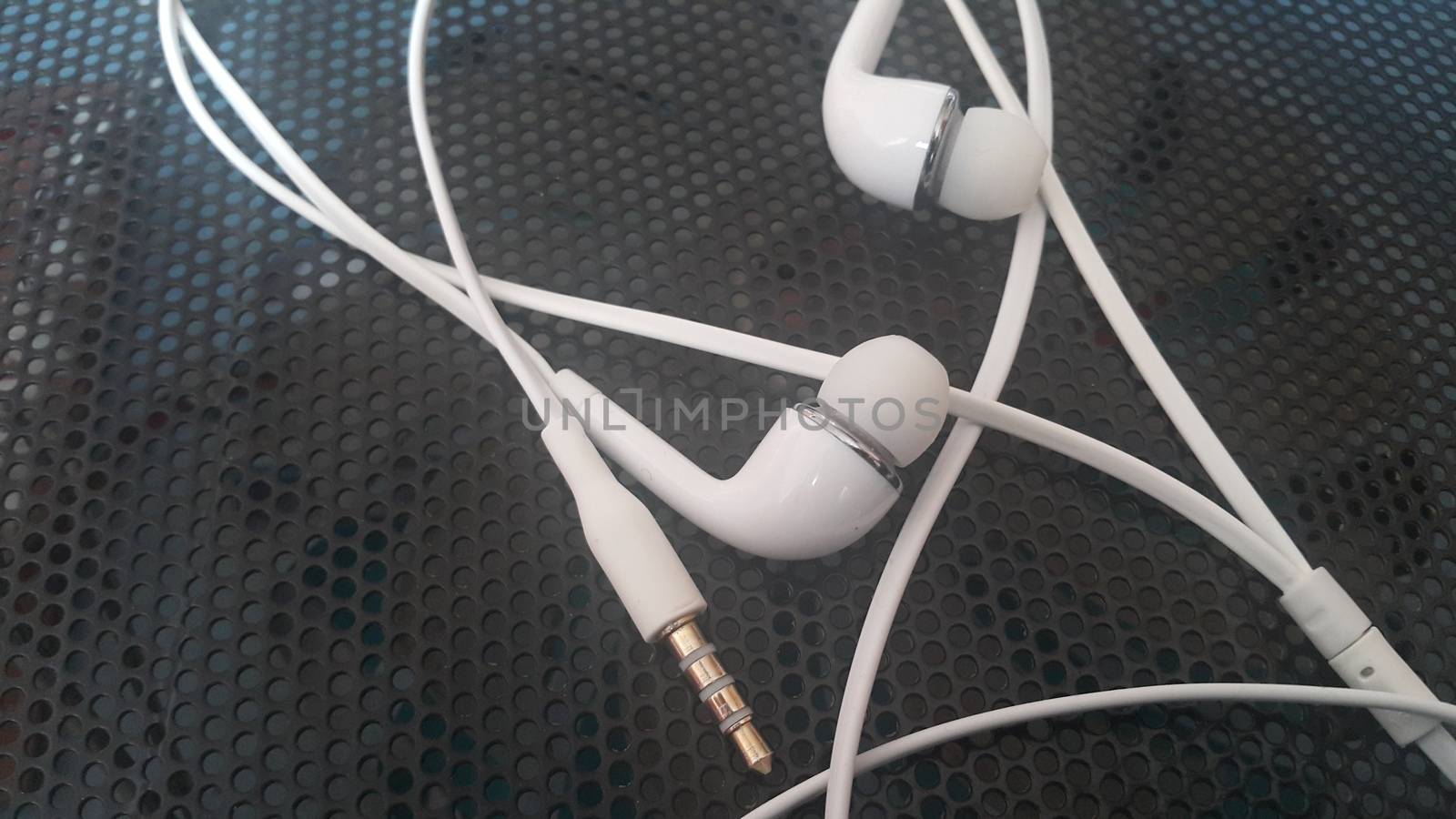 White headphones with headset lying on black background by Photochowk