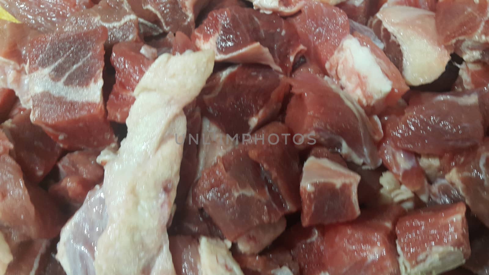 Close up view of fresh finely chopped meat cubes. Red meat small steaks with whitish meat fat.