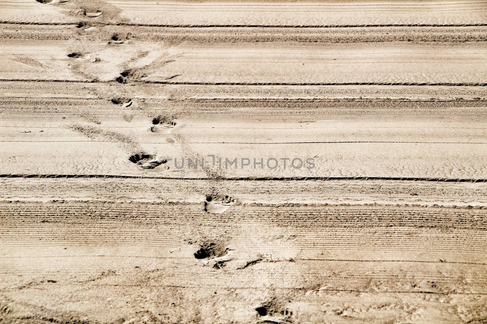 Sand racked texture with footprints on the beach in the morning