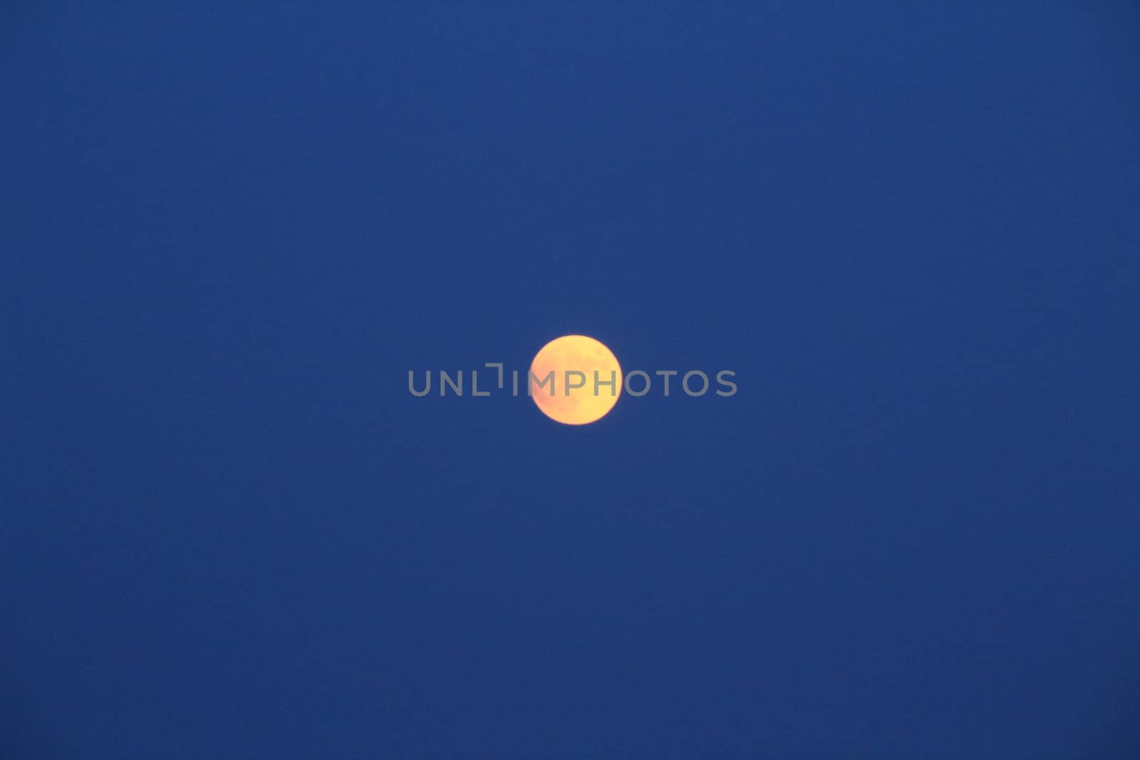 Arenales del Sol Beach in Alicante, Spain, at dusk with a full moon