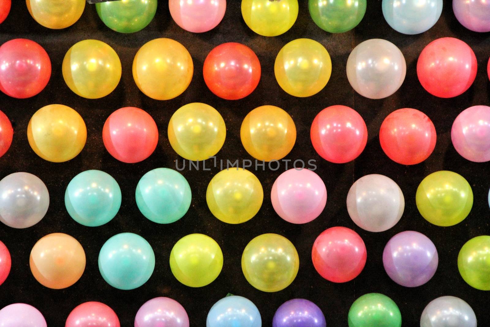 Black panel with colored balloons in a row texture in a fair
