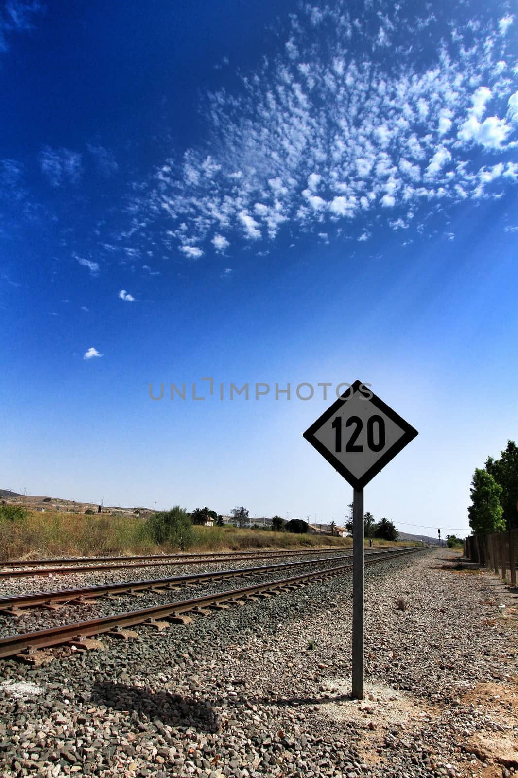 Speed sign limited to 120 km per hour next to train tracks in Spain