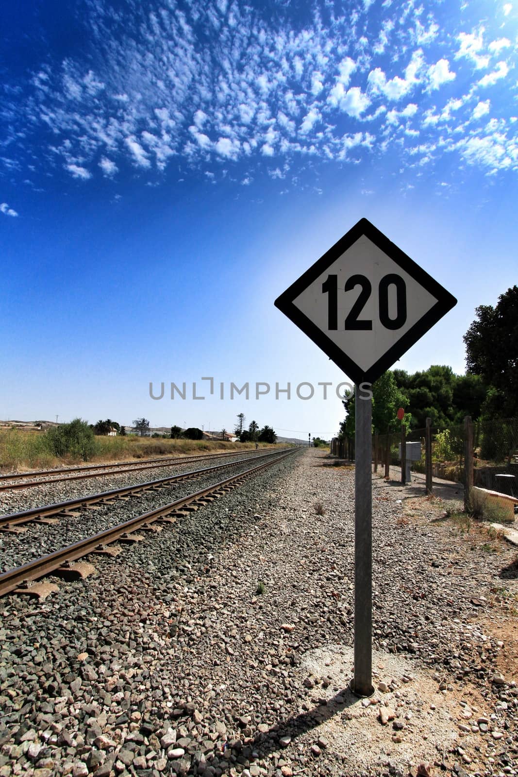 Speed sign limited to 120 km per hour next to train tracks in Spain