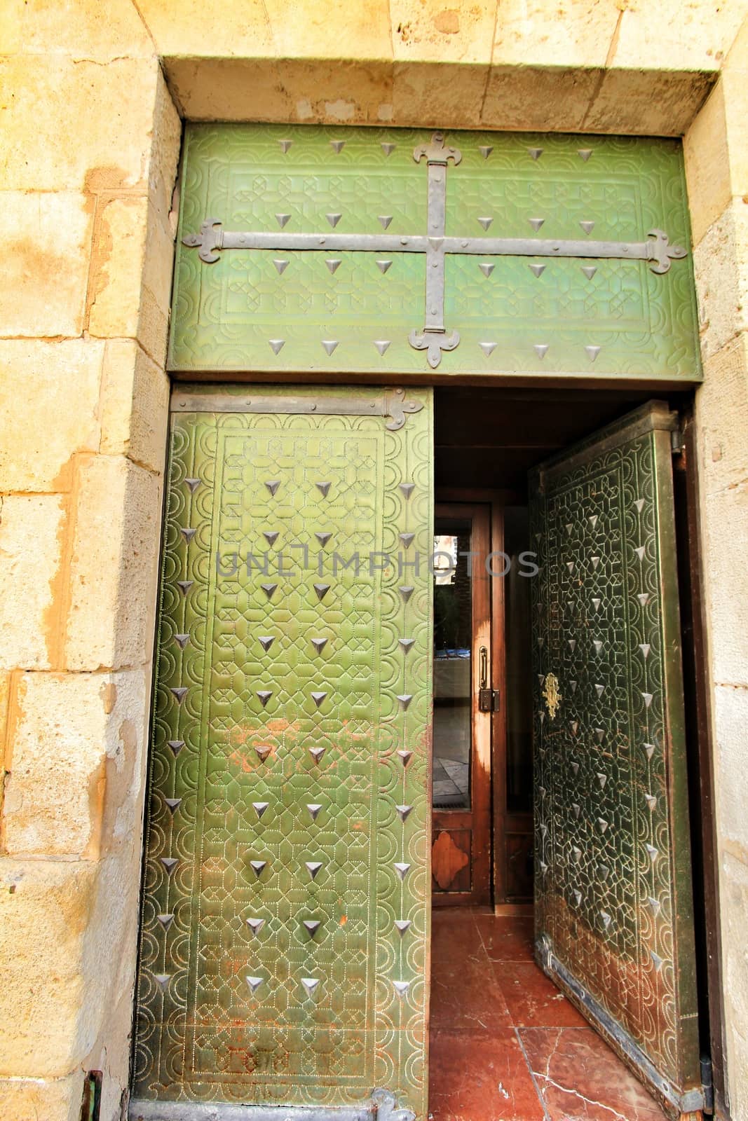 Old and colorful green wooden door with iron details in Alicante, Spain