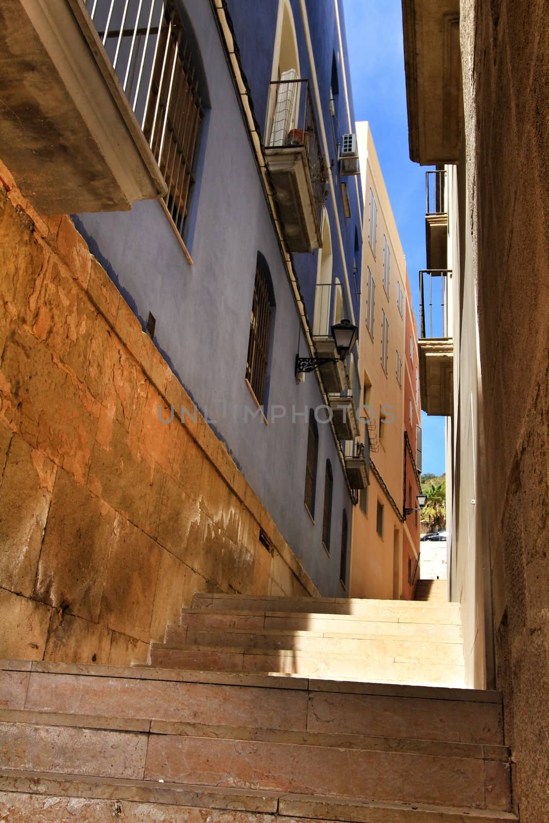Narrow streets with old facades, windows and balconies of Santa Cruz  neighborghood in Alicante city