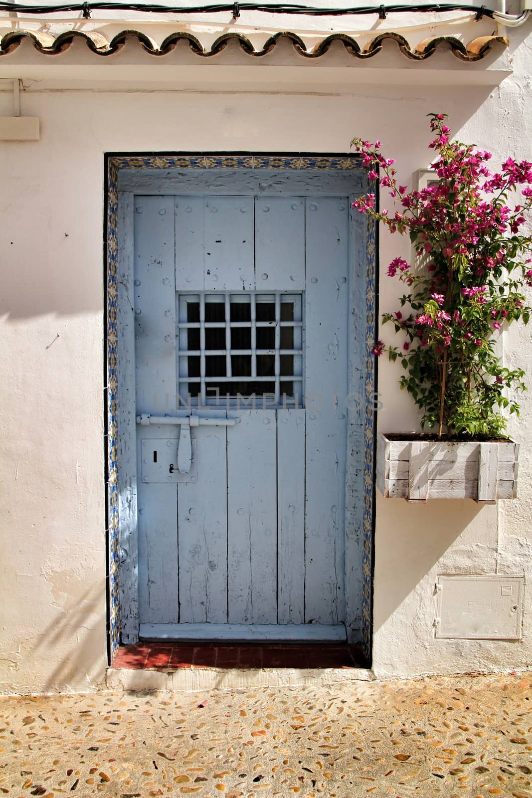 Old and colorful blue wooden door with iron details in Altea, Alicante, Spain