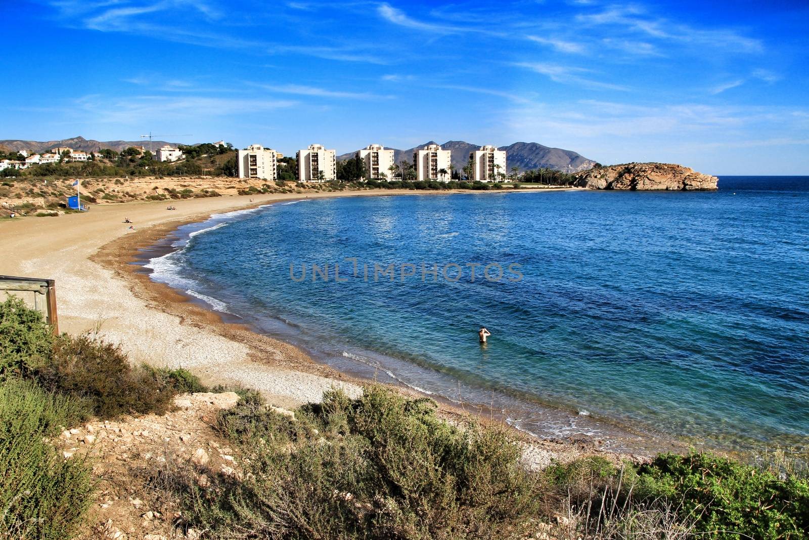 Beautiful Mojon beach in Isla Plana, Cartagena, Murcia, Spain. Buildings in the background.