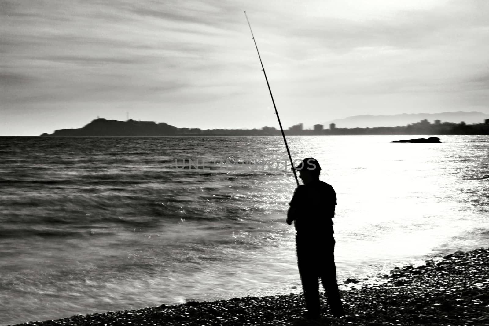 Fisherman in the evening on Mojon beach in Isla Plana, Cartagena, Murcia,Spain.