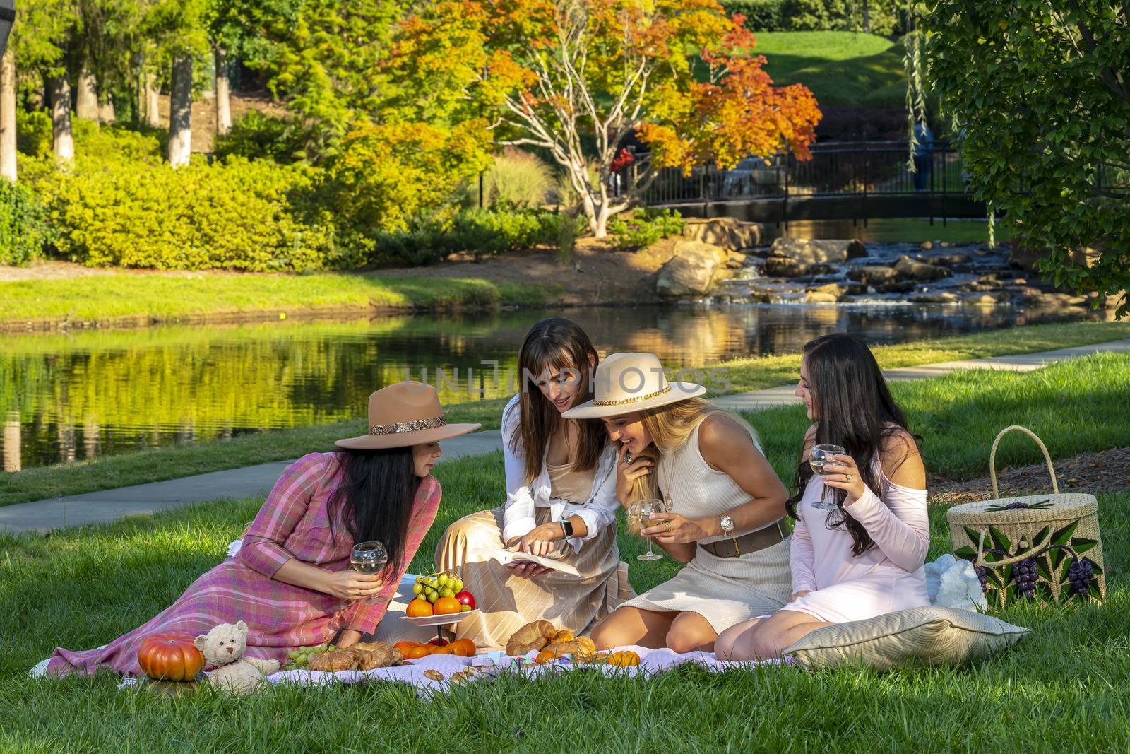 A group of beautiful women enjoy a picnic on a fall day outdoors