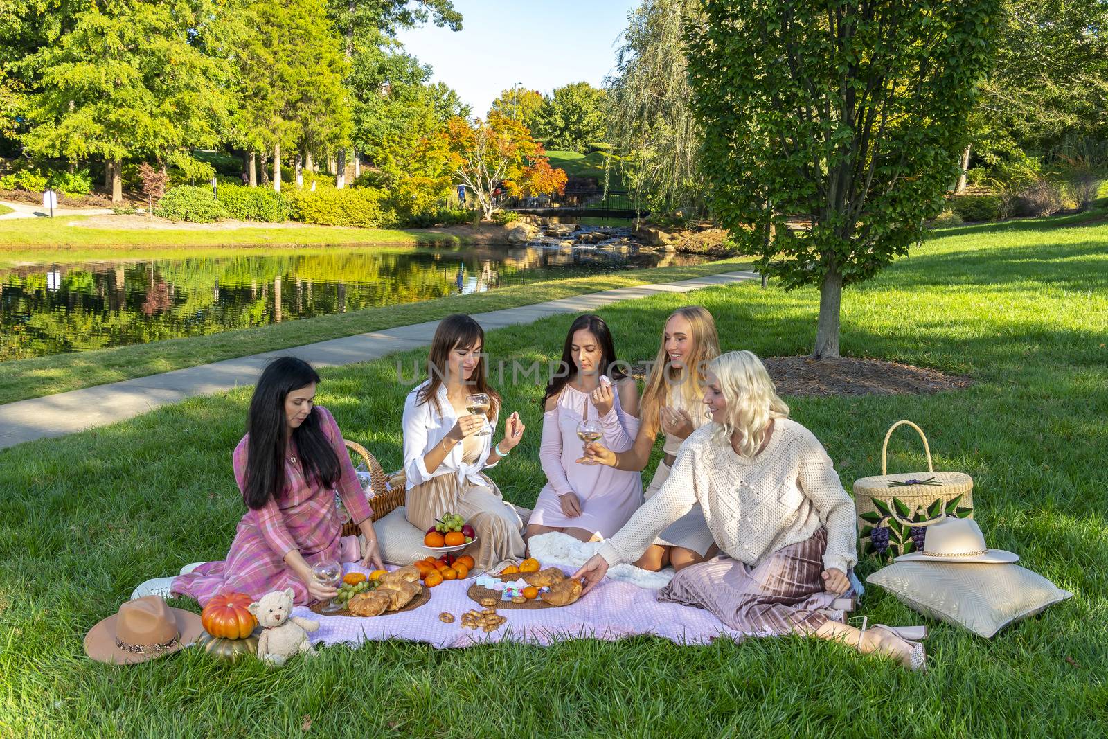 A group of beautiful women enjoy a picnic on a fall day outdoors