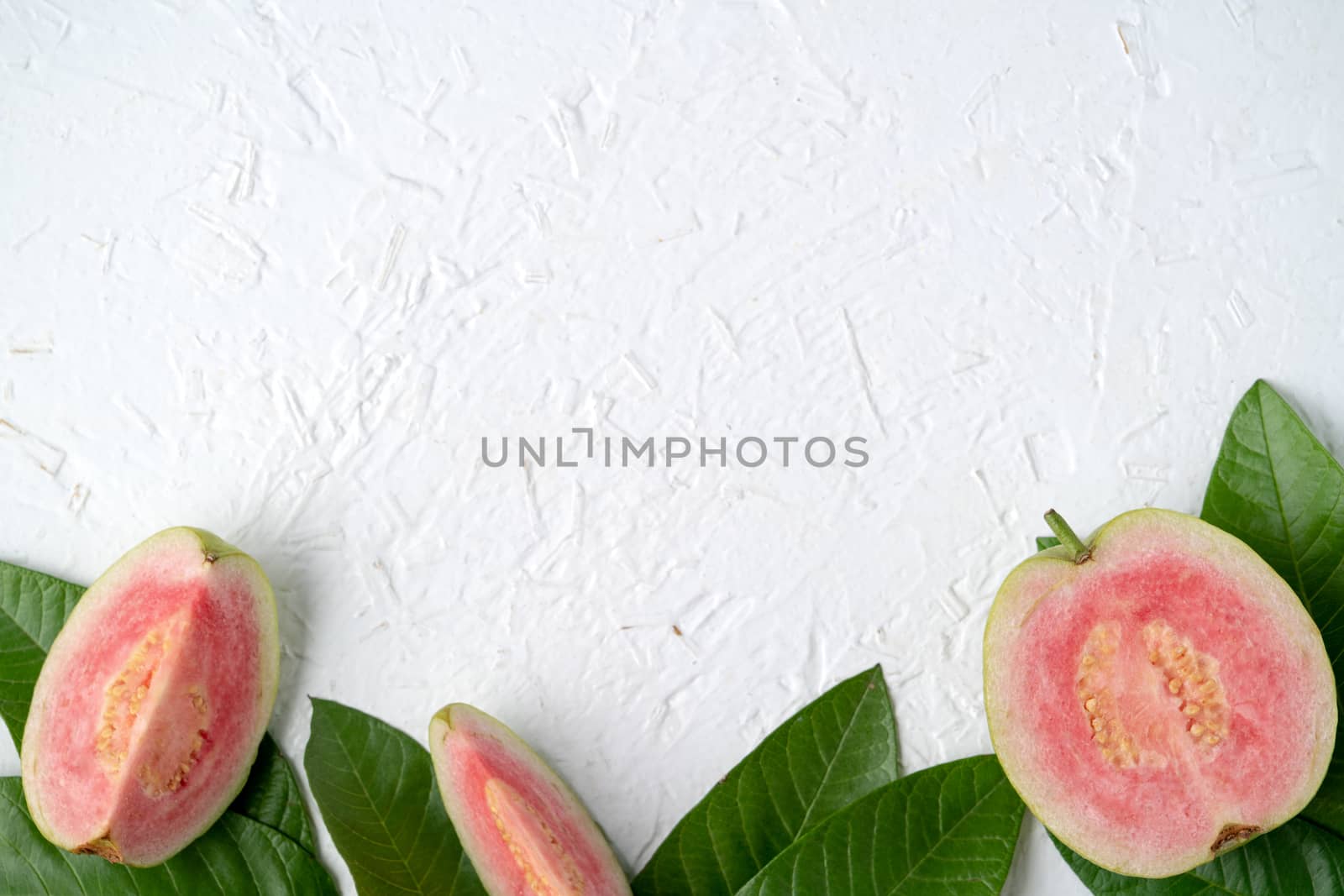 Top view, flat lay of delicious beautiful Red guava with fresh green leaves isolated on white table background, studio overhead table shot with copy space.