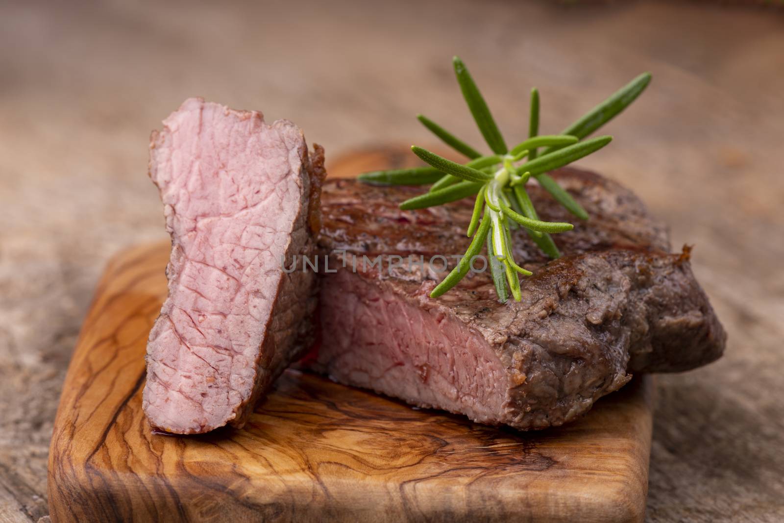 grilled steak on wood with rosemary