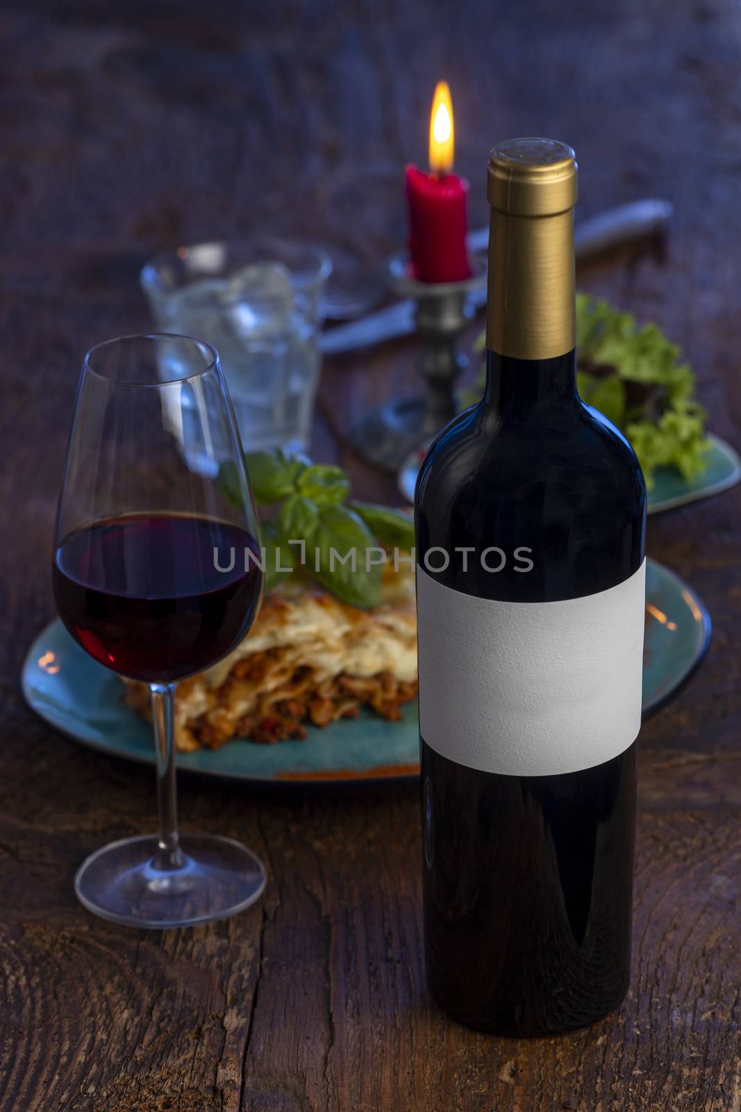 wine bottle and lasagna on wood