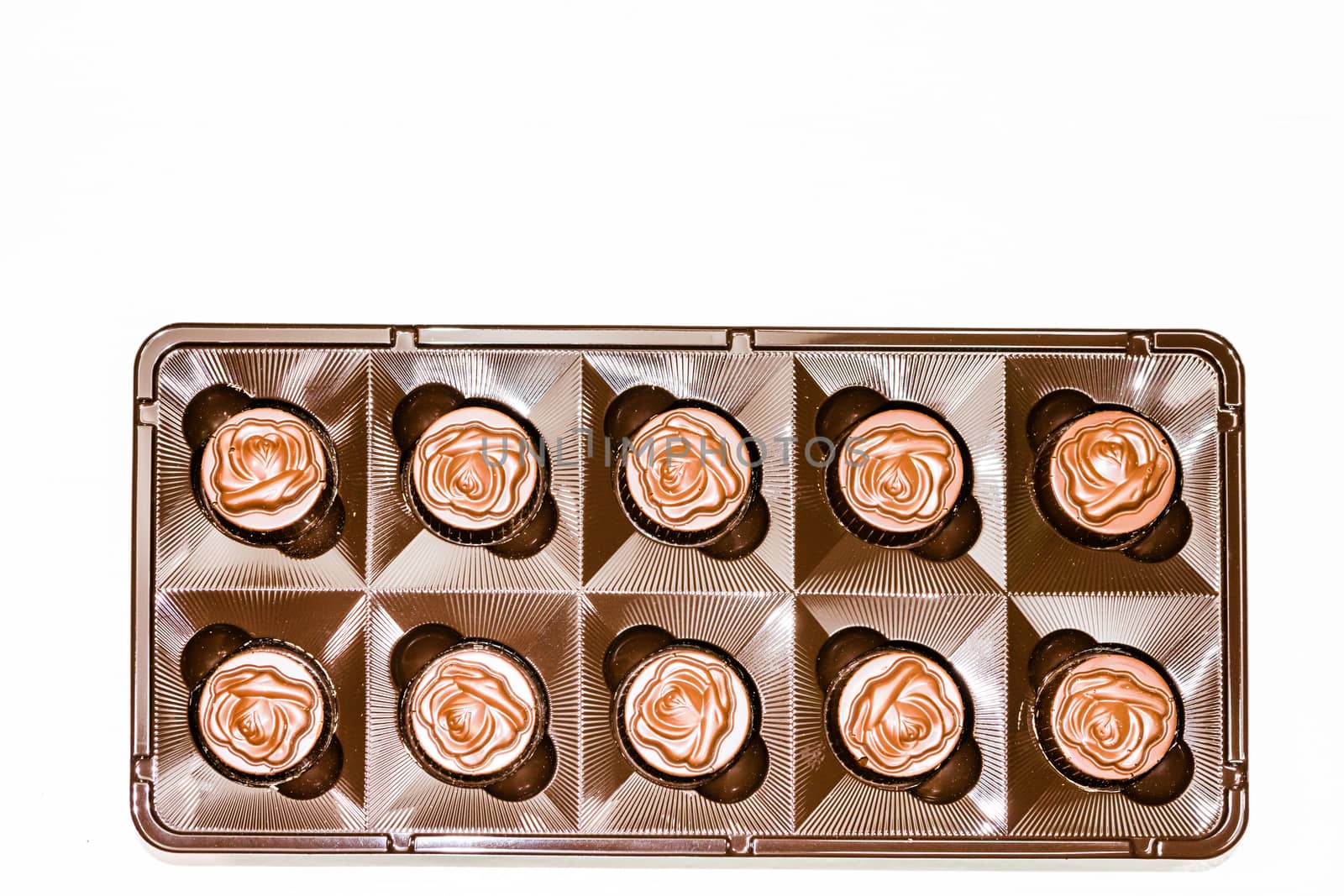 Variety of delicious chocolate pralines in box. Close up of bonbons isolated on white, selective focus.