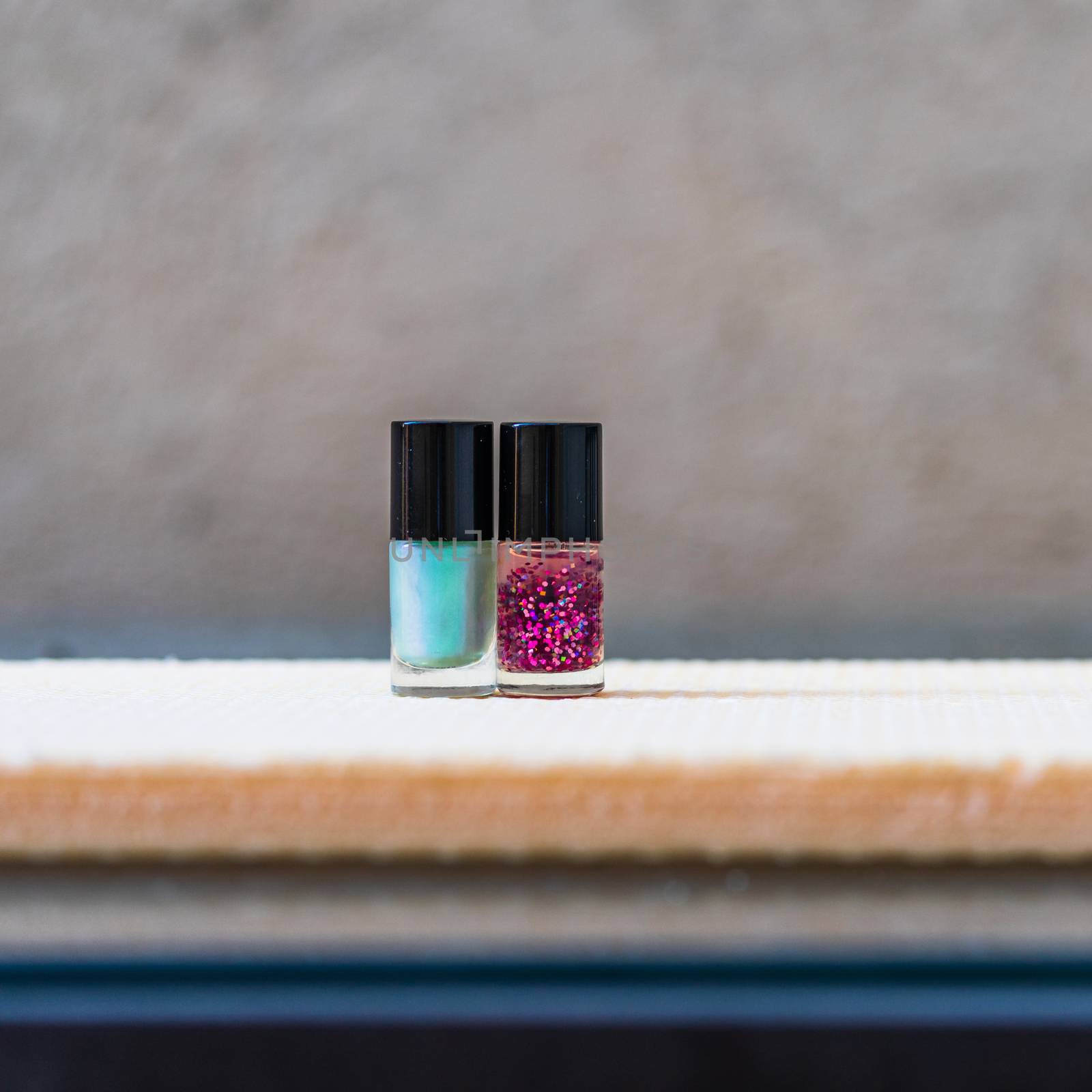 Close up photo of colorful, bright and glittery nail polish bottles isolated with copy space.