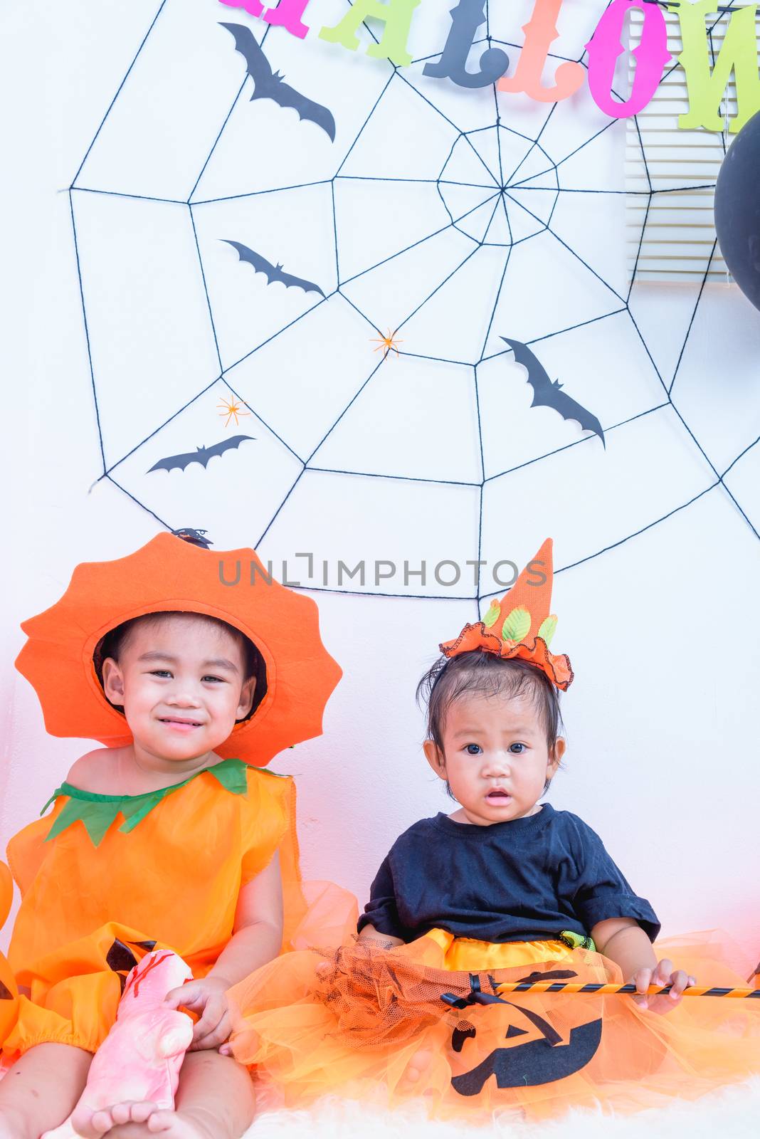 Funny happy brethren baby girl and kid boy in Halloween costume  by Sorapop