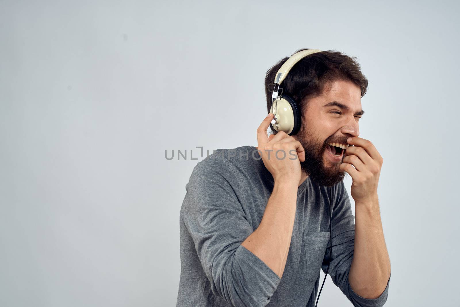 Man in headphones listens to music lifestyle modern style technology light background. High quality photo