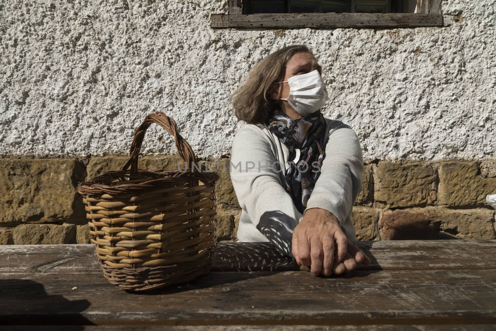 A senior woman, wearing face mask, stretches her arms, Spain by alvarobueno