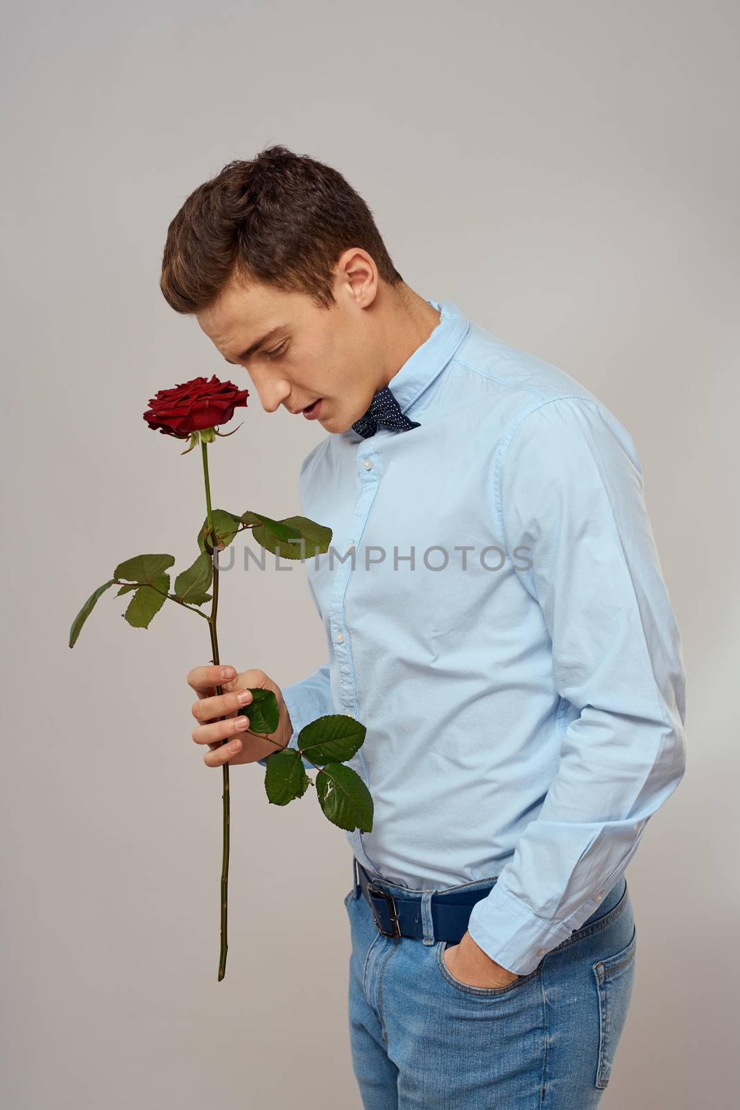 romantic man with red rose and light shirt pants suit. High quality photo