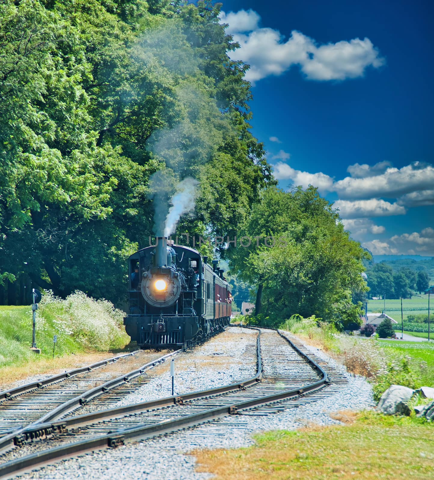 Restored Antique Steam Locomotive with Passenger Cars Steaming Up