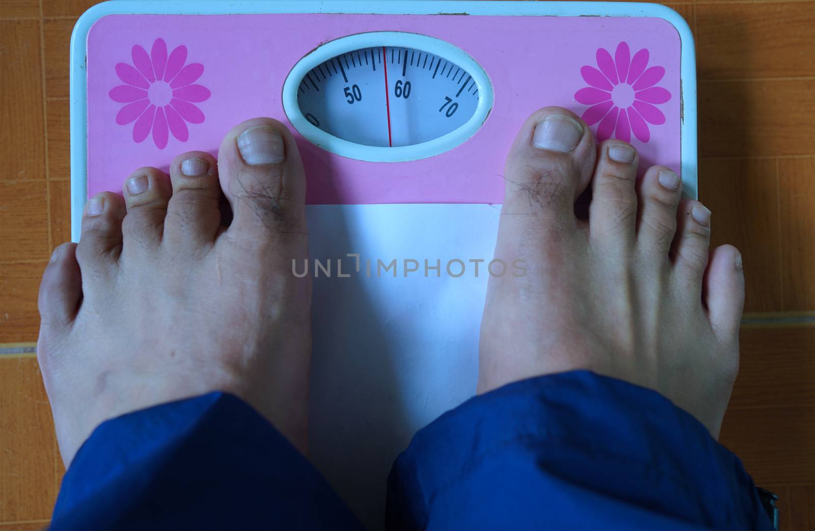Foot on the weight scale, health and weight management concept.