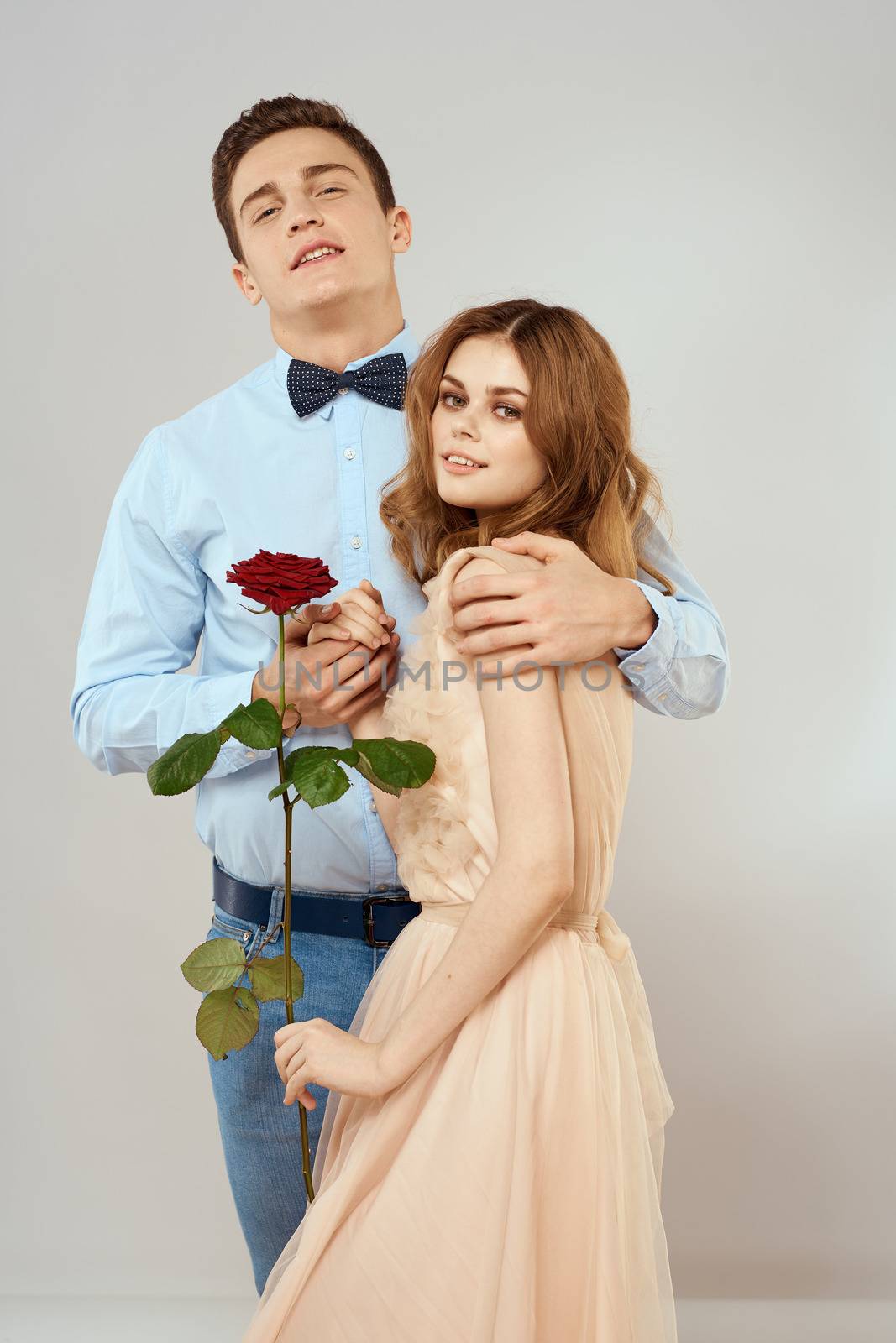 Young couple hugs romance dating lifestyle relationship light background red rose by SHOTPRIME