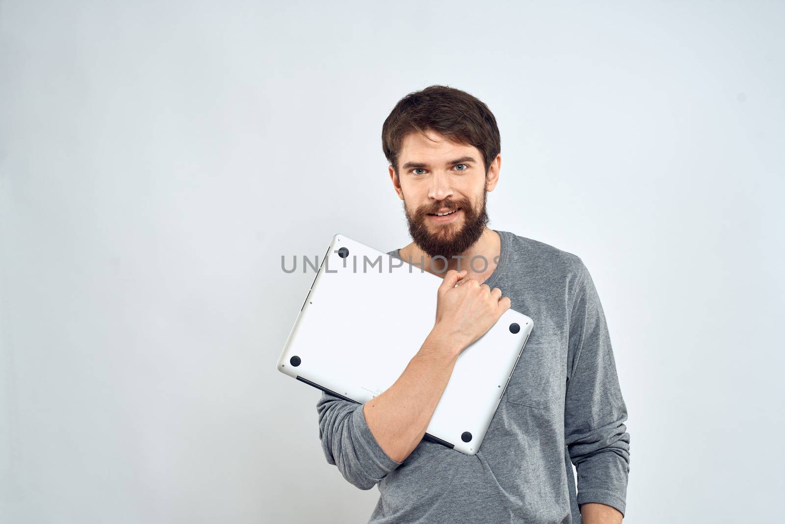 Man with laptop in hands technology internet self-confidence light background by SHOTPRIME