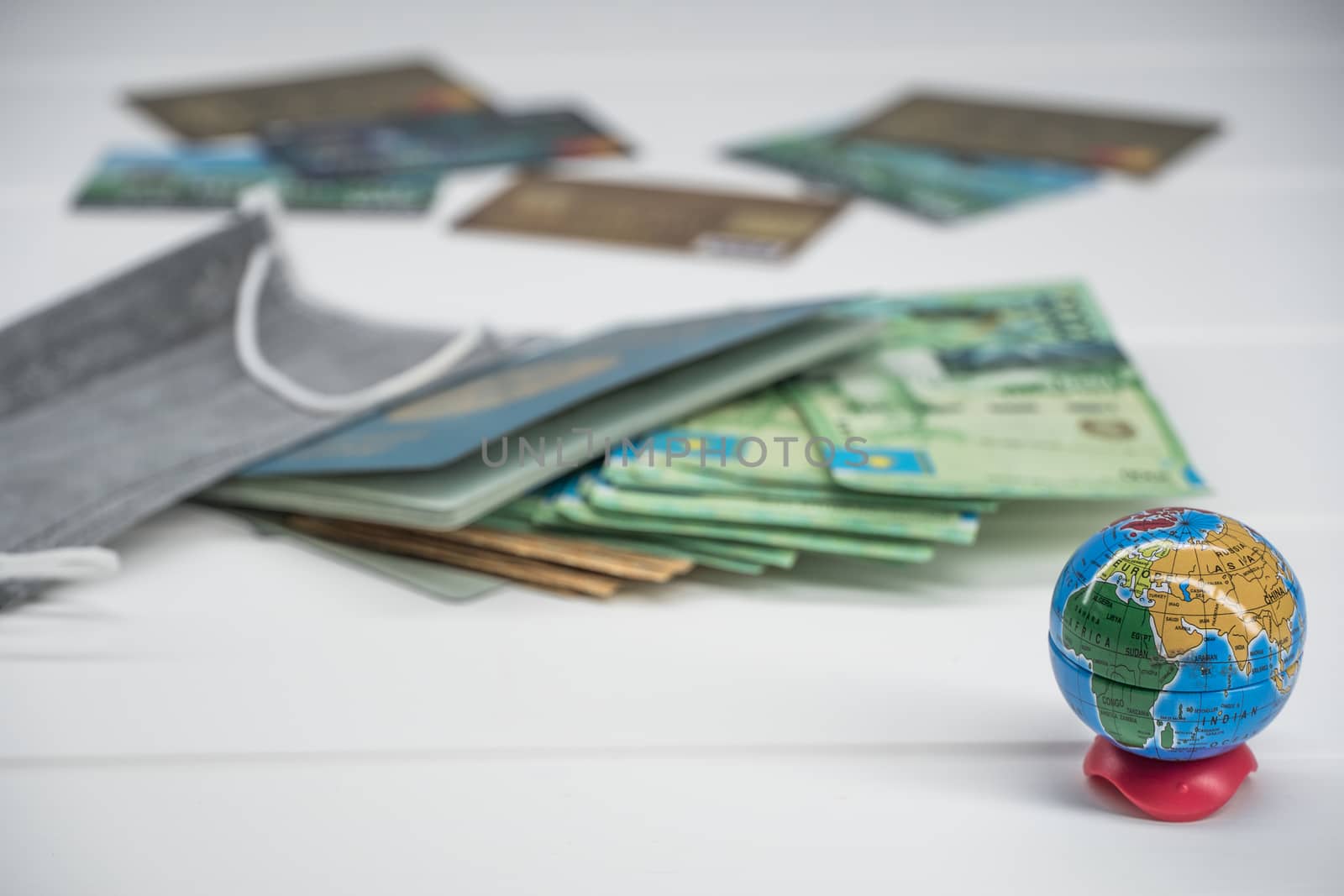 Quarantine in Kazakhstan. Tenge money with medical face masks, a globe, a card and a passport are on the table. The closure of borders and travel in Kazakhstan.