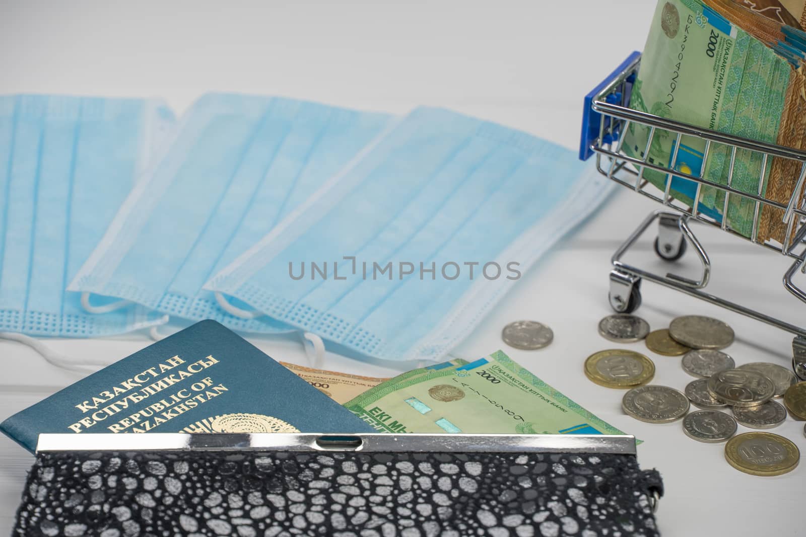 Quarantine in Kazakhstan. Tenge money with medical face masks, a globe, a card and a passport are on the table. The closure of borders and travel in Kazakhstan.