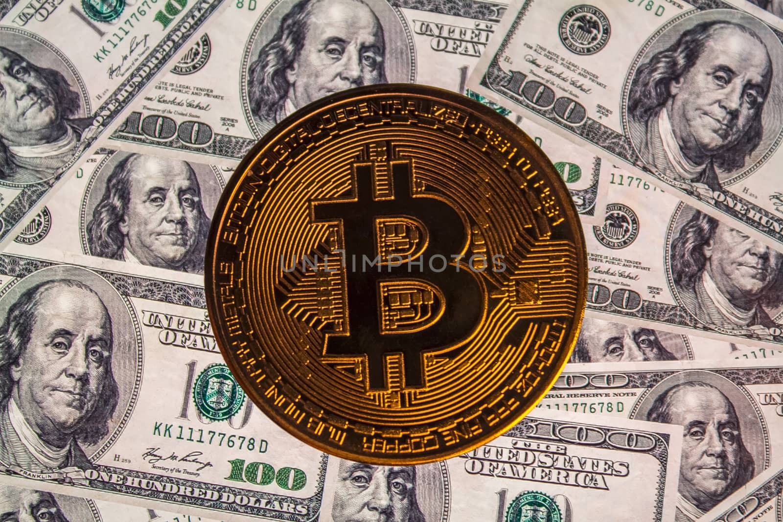 Bitcoin coin against the background of us dollars. A lot of American money dollars and gold bitcoin. Background of money and cryptocurrency.Money background. Screen full of dollars close up.