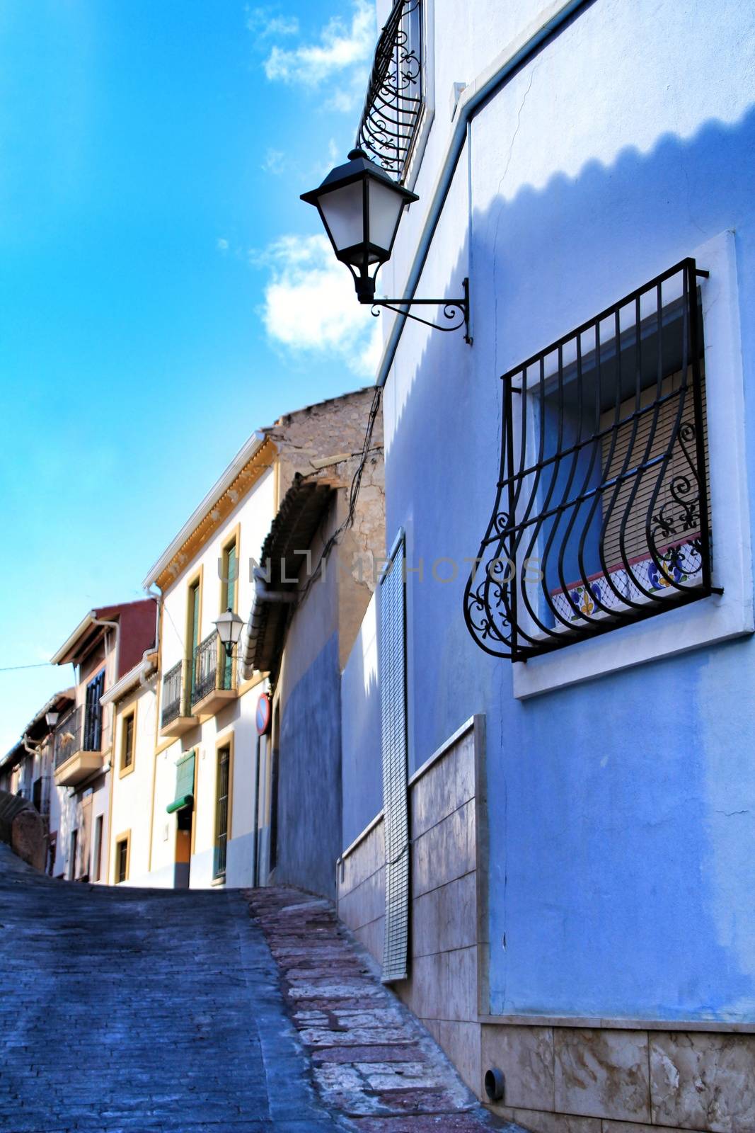 Streets and colorful facades of the town of Hondon de Las Nieves in Alicante, Spain under blue sky