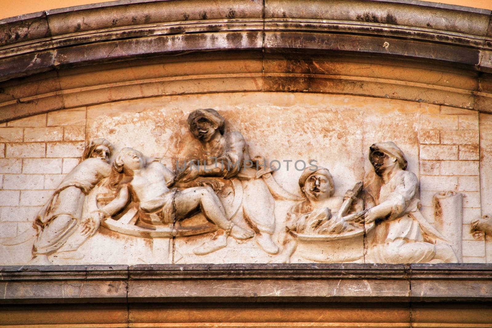 Scene carved in stone on facade of old and majestic house in Cordoba , Spain