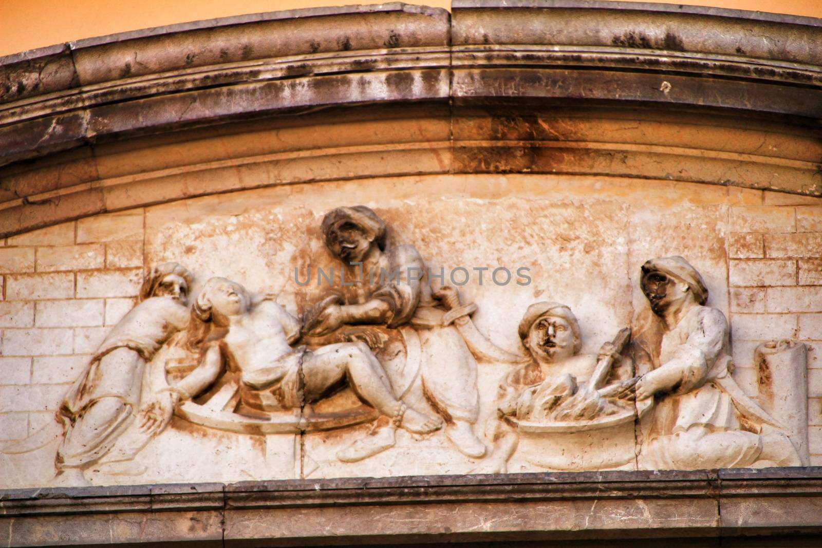 Scene carved in stone on facade of old and majestic house in Cordoba , Spain