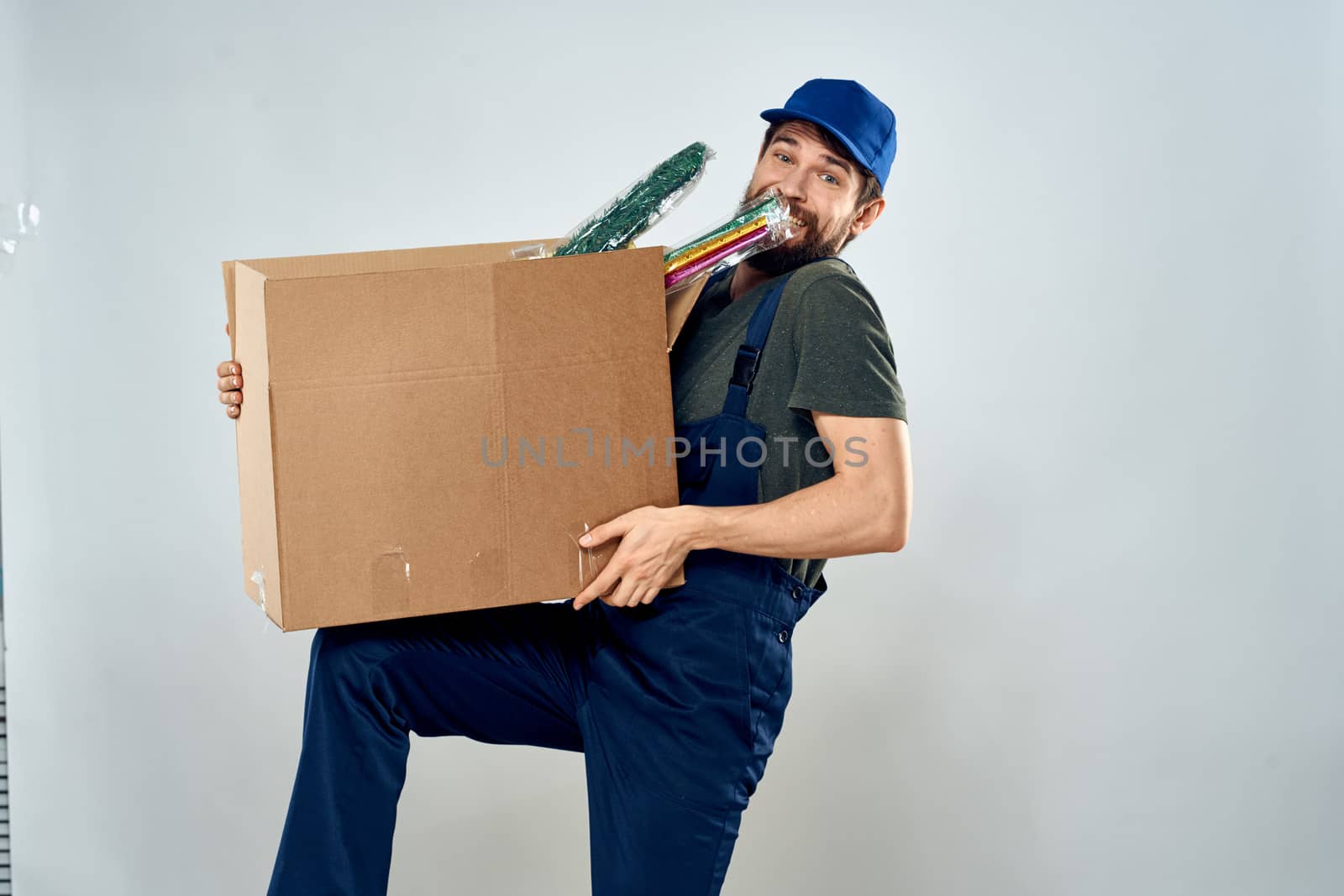 Man in working uniform with boxes in hands delivery loading lifestyle. High quality photo