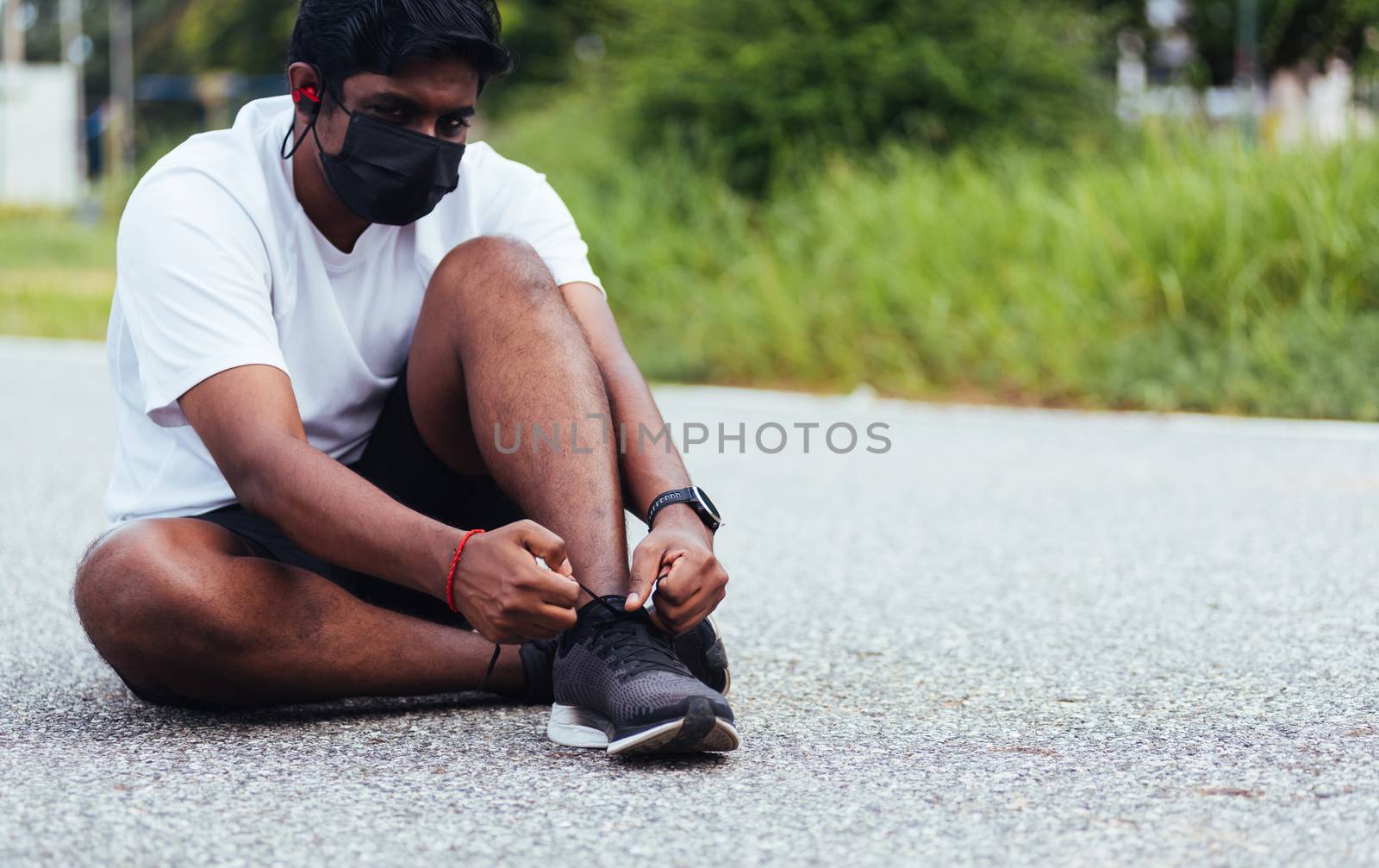 Close up Asian sport runner black man wear face mask protective he shoelace trying running shoes getting ready for jogging and run at the outdoor street, health exercise workout concept