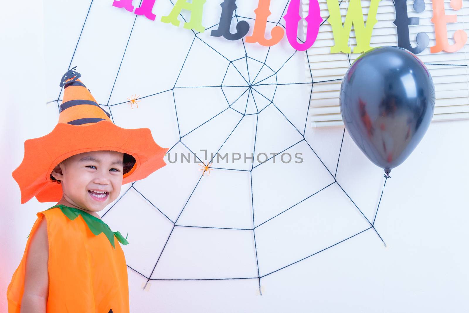Funny happy kid in Halloween costume with pumpkin Jack by Sorapop