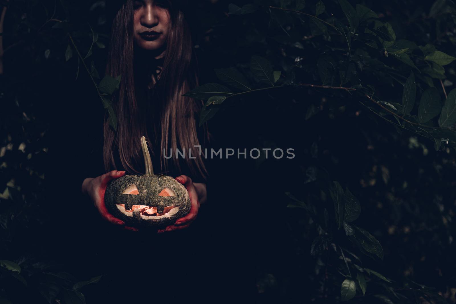 Portrait of woman ghost horror her have pumpkin on hand in forest, halloween day concept