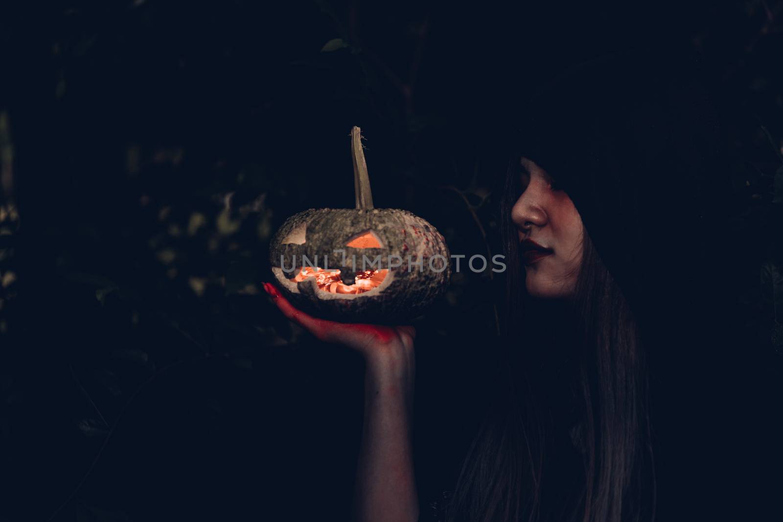 Portrait of woman ghost horror her have pumpkin on hand in forest, halloween day concept