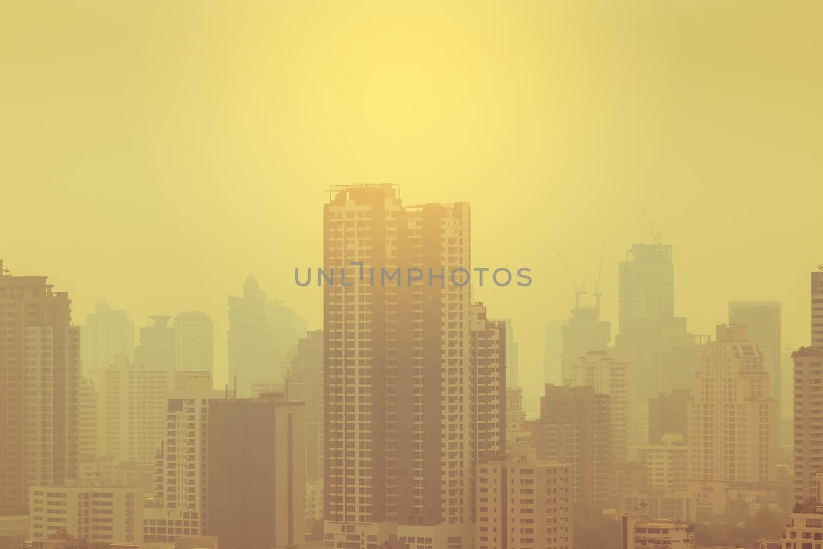 smog city in summer with morning sunlight, haze of pollution covers city, global warming concept