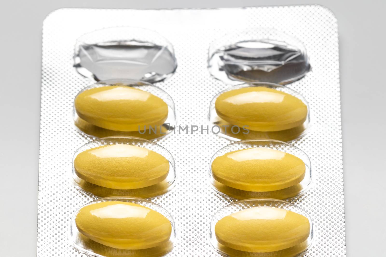 yellow pills in blister pack, medicines for health, pharmaceutical health care and sciences concept, shallow depth of field