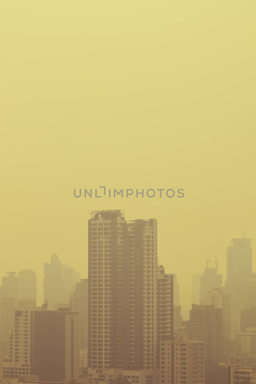 smog city in summer with morning sunlight, haze of pollution covers city, global warming concept