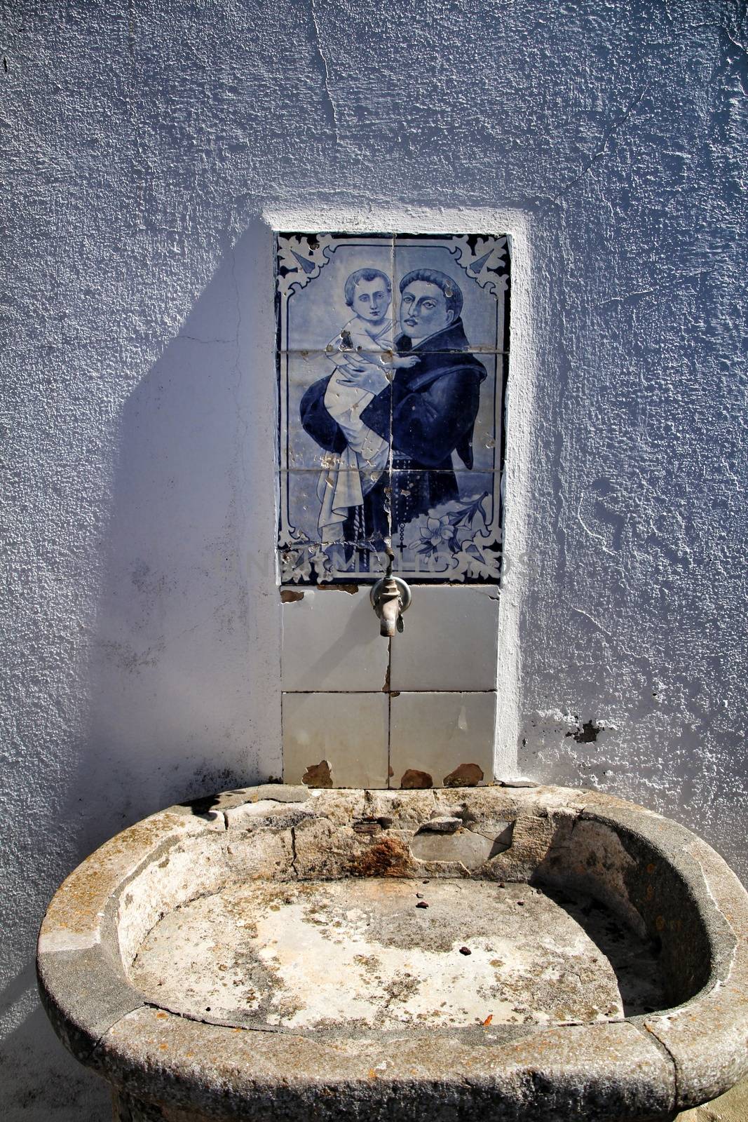 Old stone fountain with blessed water by saint in Azenhas do Mar in Lisbon, Portugal