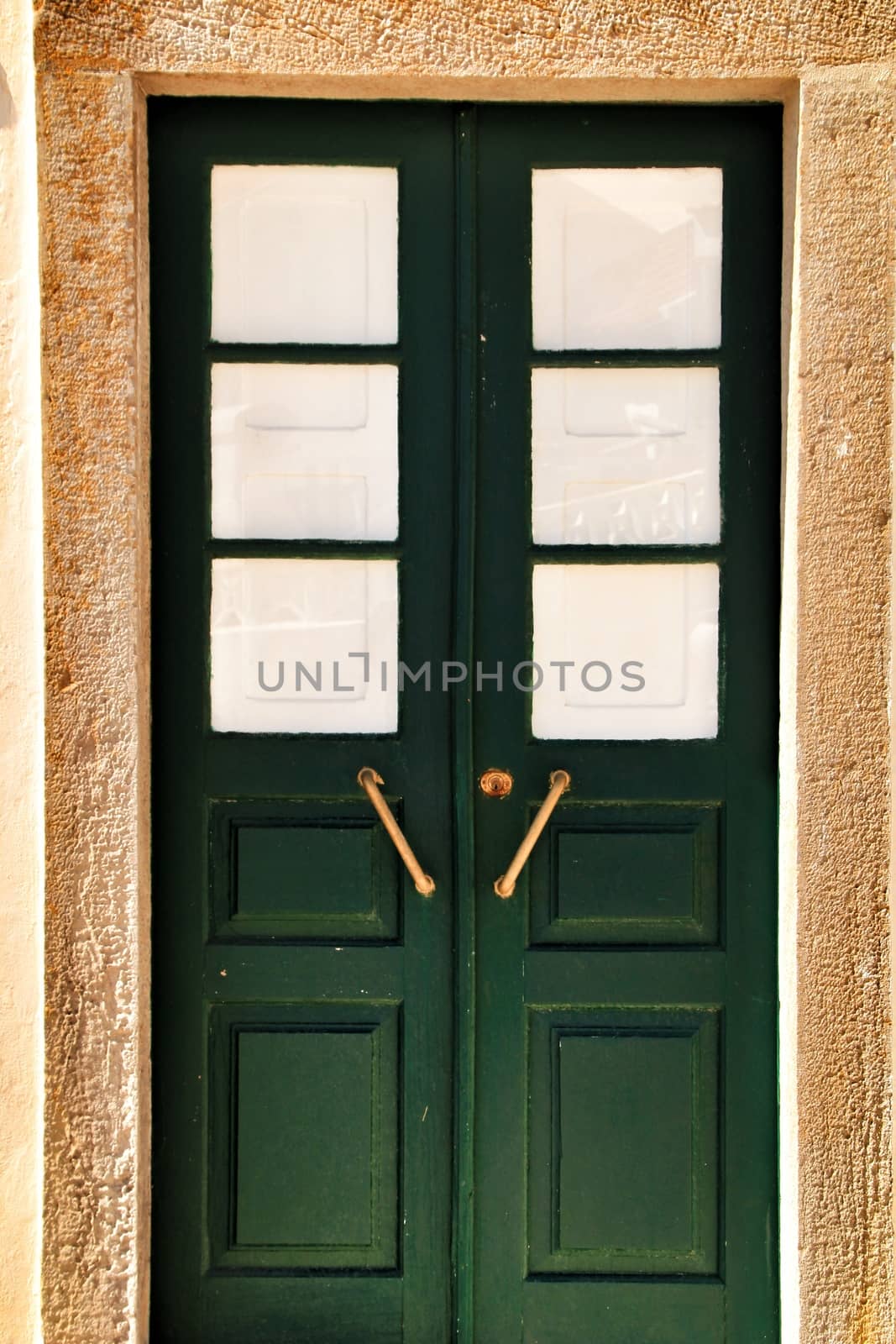 Colorful green wooden door with iron details in Lisbon, Portugal