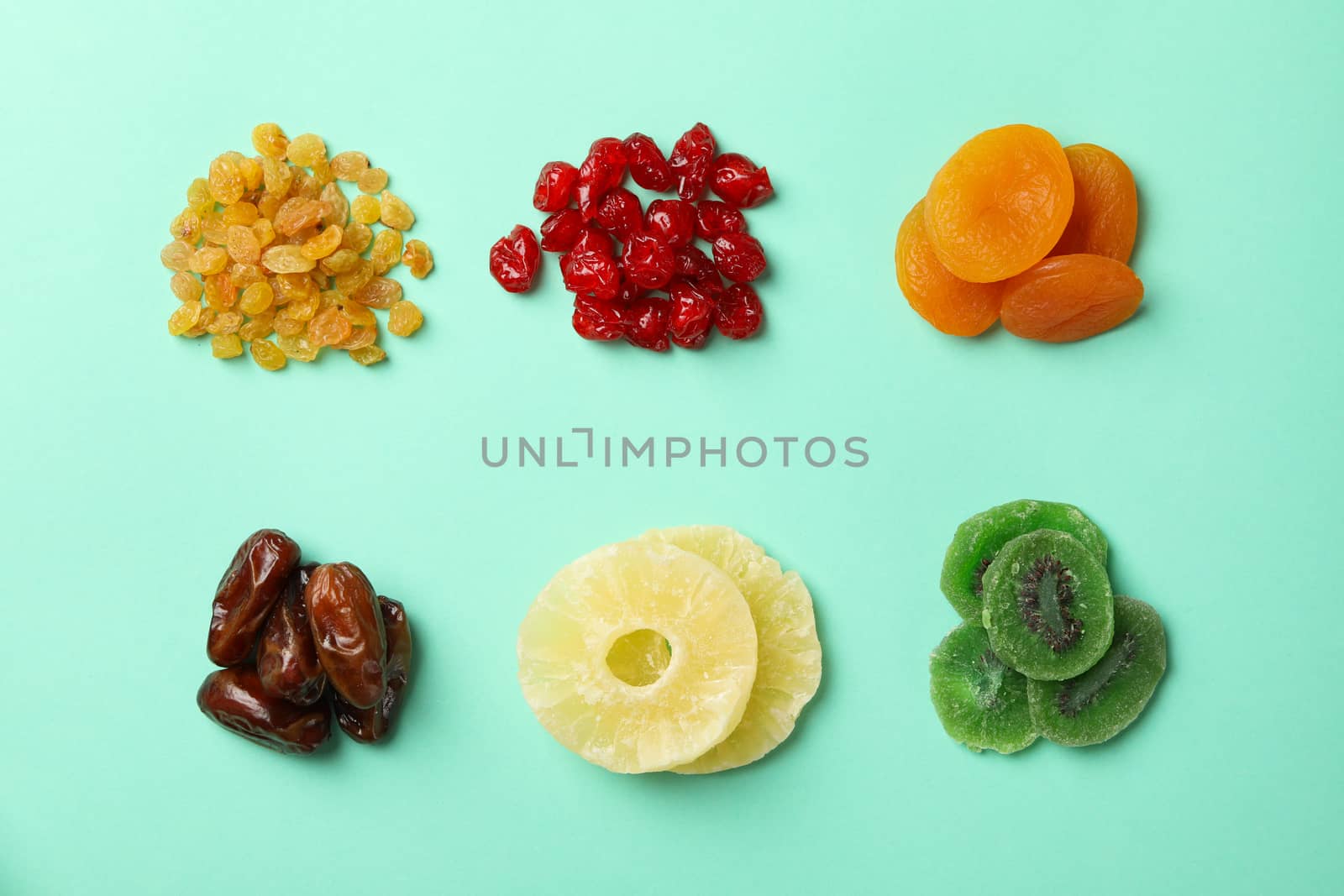 Tasty dried fruits on mint background, top view