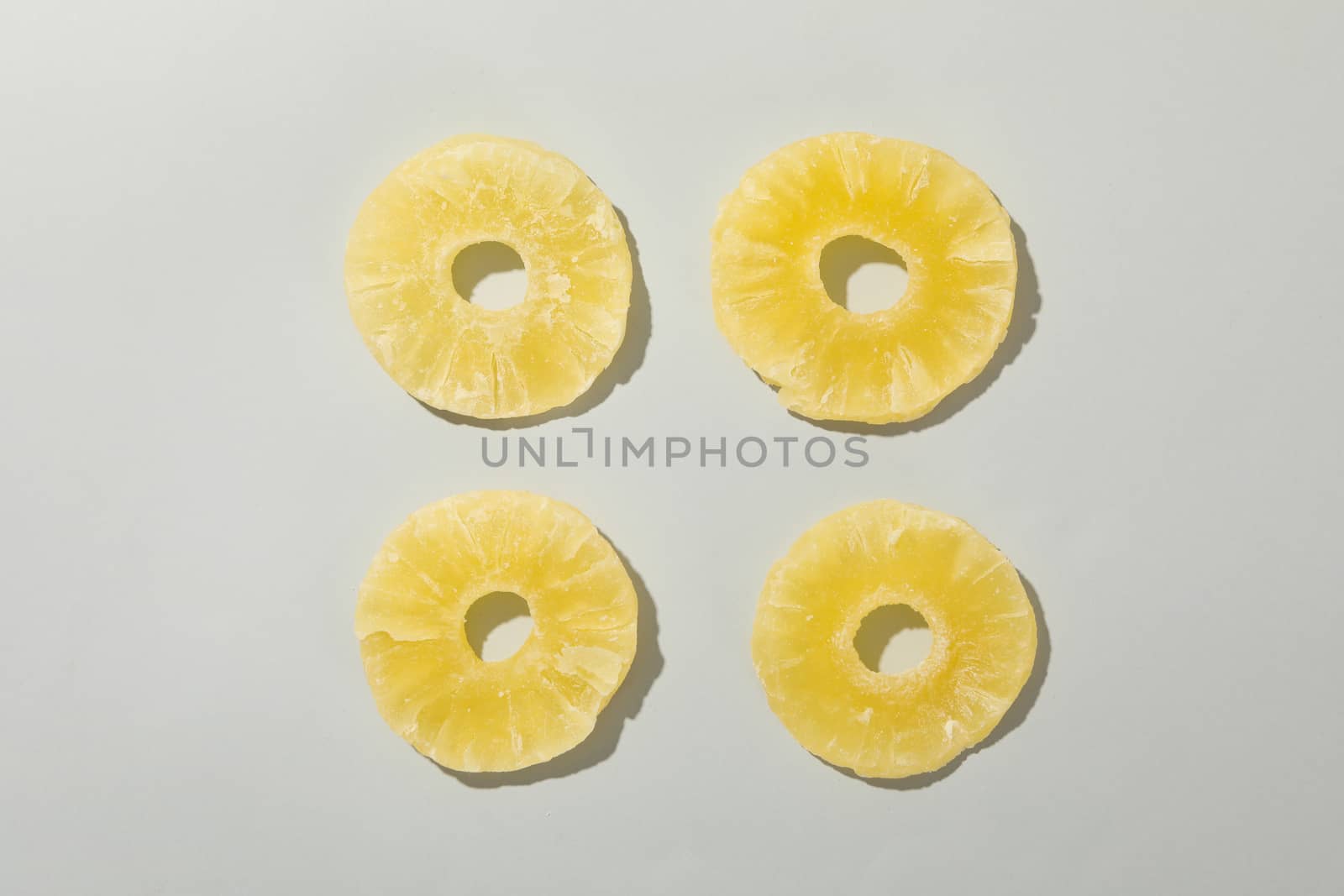 Dried pineapple slices on white background, top view